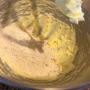 flour being added to creamed butter