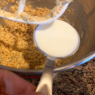 milk being added to flour mix in a bowl