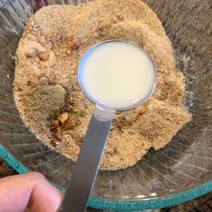 milk being added to a bowl of flour