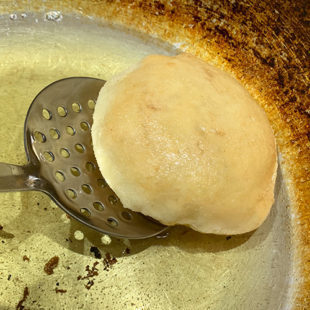 puffed up fried dough in oil