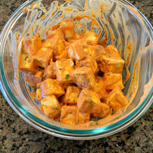 paneer cubes marinated with yogurt and spices in a bowl