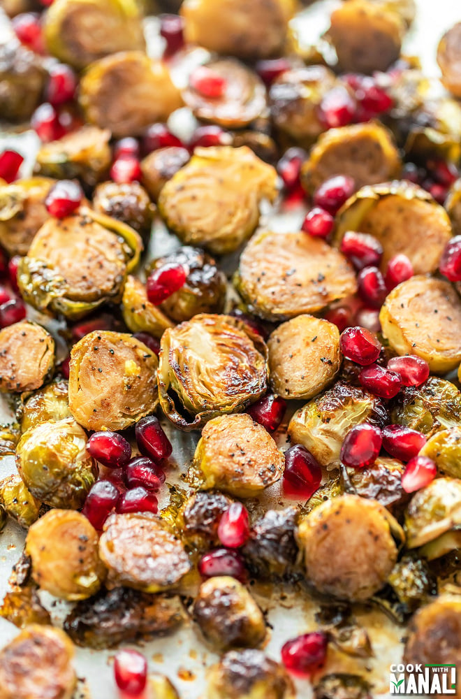 roasted brussel sprouts in a baking pan with pomegranate