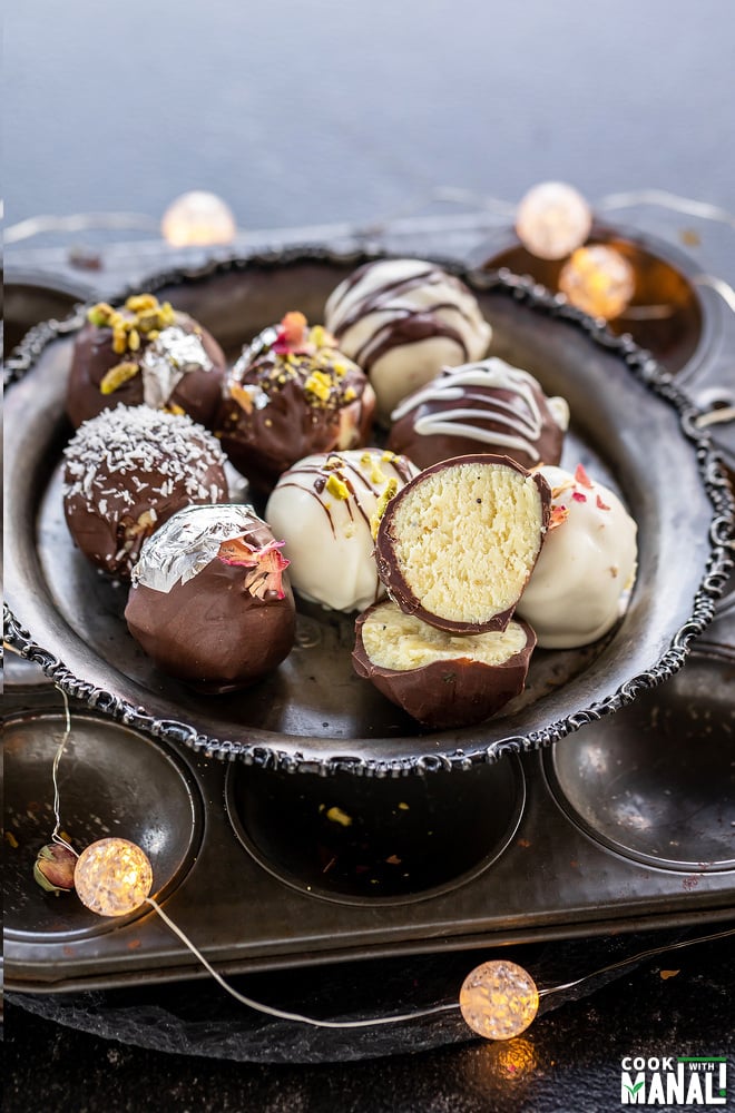 burfi truffles arranged on a plate with string of light around it