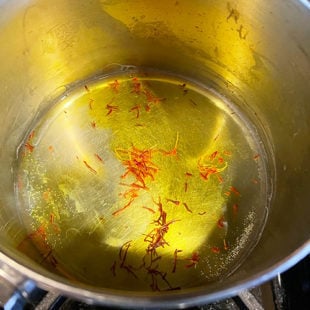 saffron strands in water in a pan