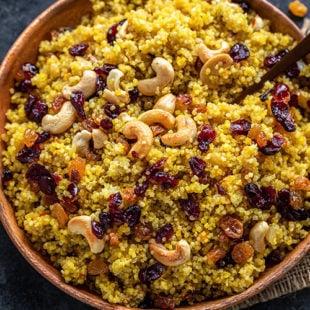 cooked saffron quinoa topped with nuts and raisins