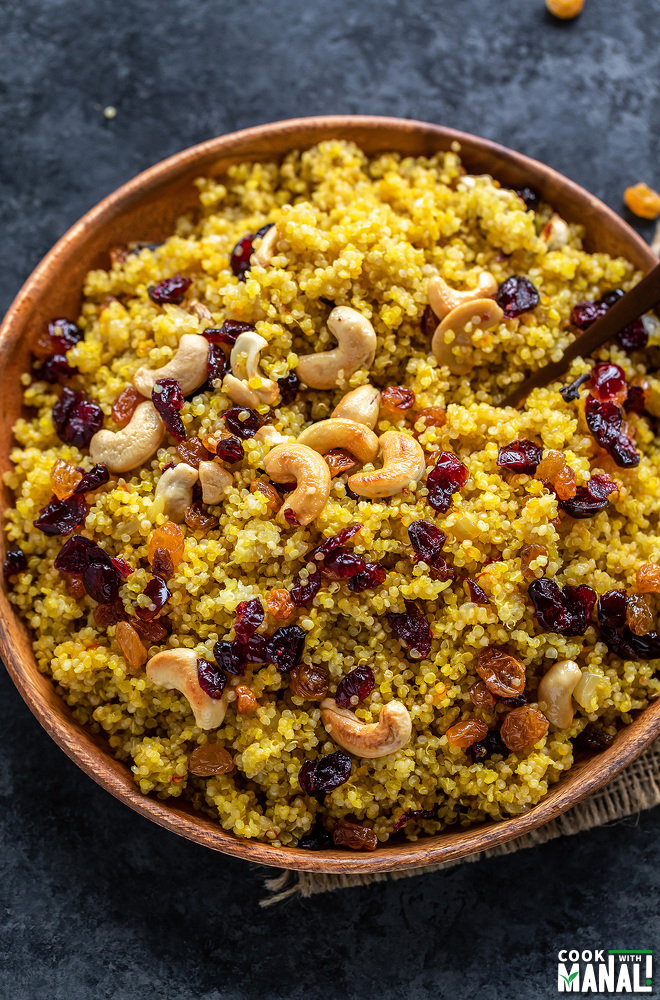 plate of saffron quinoa topped with roasted cashews, raisins and cranberries