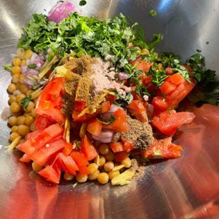 bowl with chopped onion, tomato, cilantro, white peas and spices