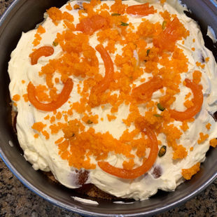 crushed ladoo and broken jalebi spread over cream cheese filling in a pan