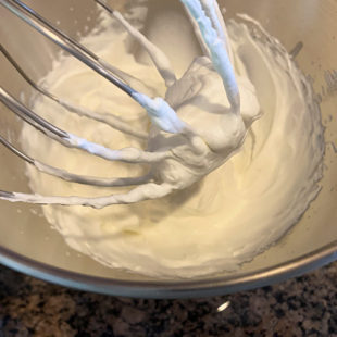 wire whisk attachment showing whipped cream