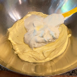 whipped cream being folded into cream cheese mixture