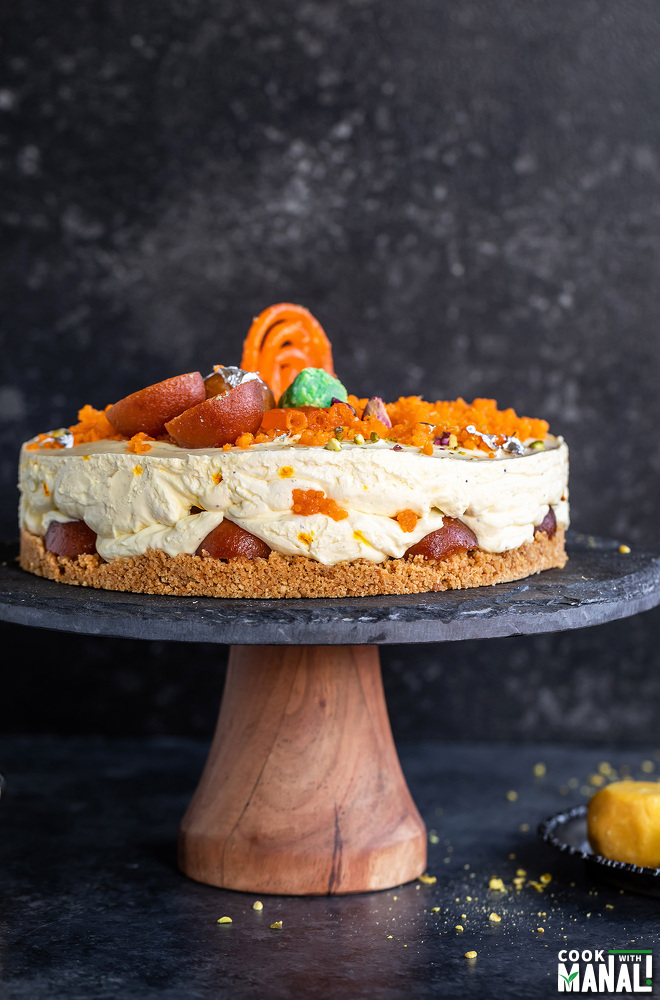 mithai cheesecake on a wooden cake platter