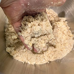 hand picking up flour to show how crumbly it is