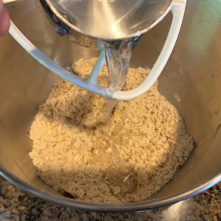 water being added to flour mix in a bowl