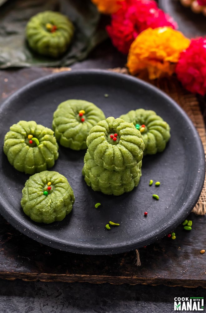 2 paan peda stacked on top of one another with a string of flowers in the background