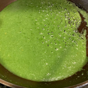 green color liquid bubbling in a pan