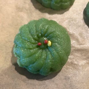 green color shaped peda garnished with mukhwas