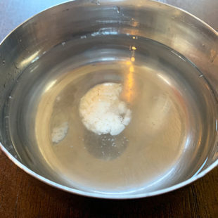 small portion of batter floating in a bowl full of water