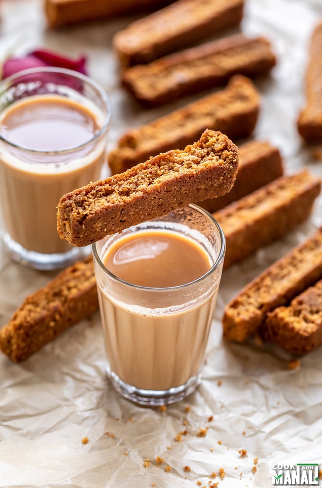 a rusk placed on top of a glass of chai
