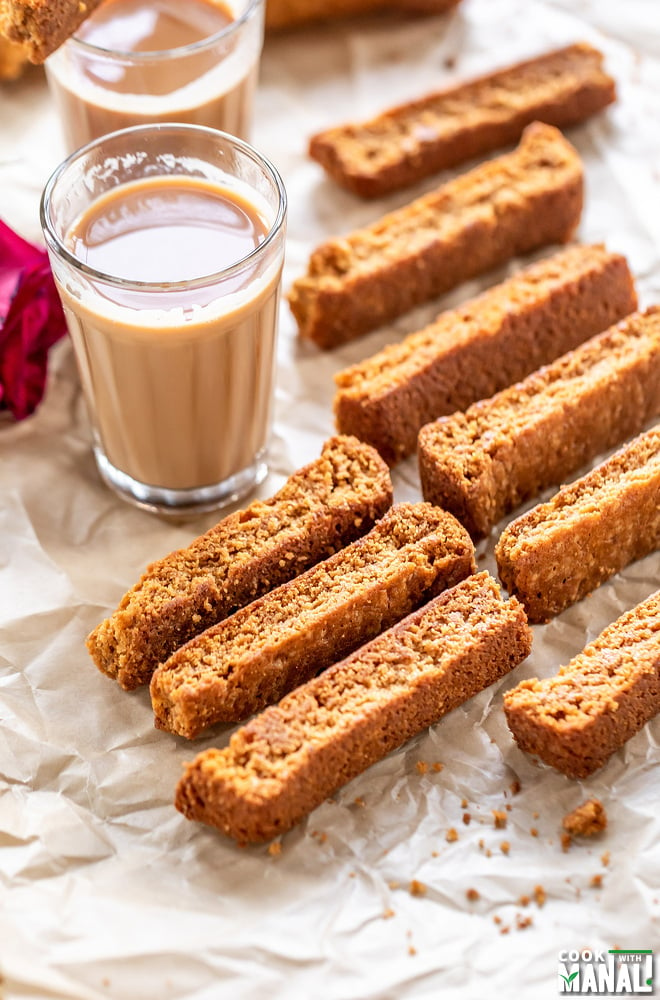 some rusk arranged on a tray with chai glasses in the background