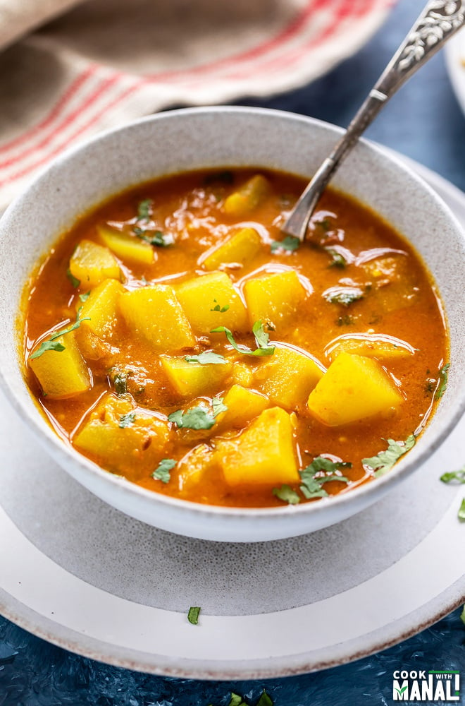 a spoon digging into a bowl of curry