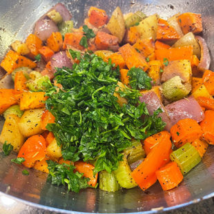 chopped parsley added to a bowl of diced veggies