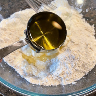 oil being added to a bowl of semolina