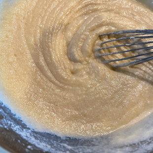 a thick batter being whisked by a wire whisk