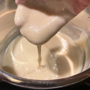 batter flowing through a hand to show the consistency