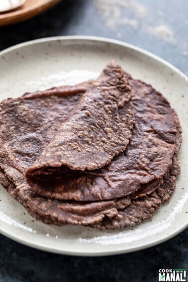 few ragi roti placed on a white plate