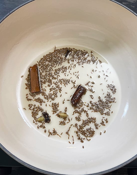 whole spices in oil in a pot