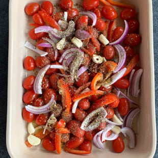 baking dish with cherry tomatoes, onions, spices