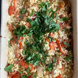 pasta in a baking dish topped with chopped basil