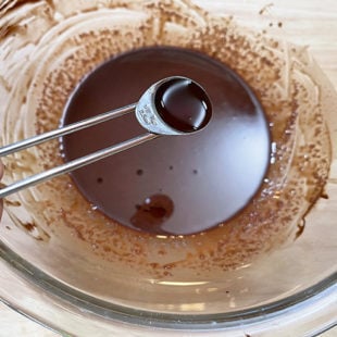 vanilla being added to a bowl of melted chocolate