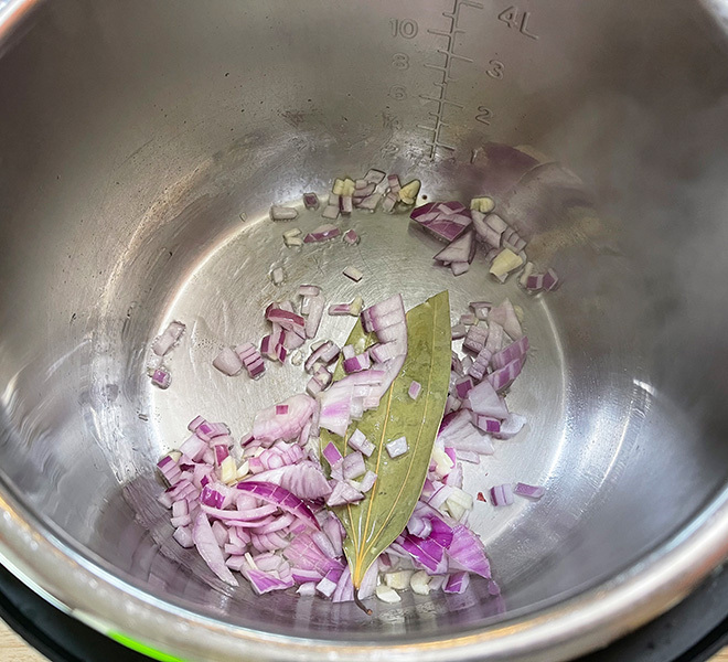 pot with sautéed onions and a bay leaf