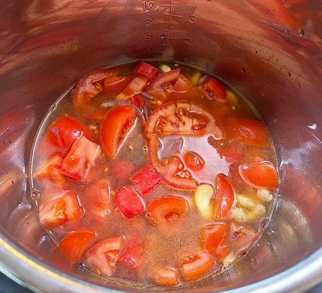 chopped tomatoes with cashews and water in a pot