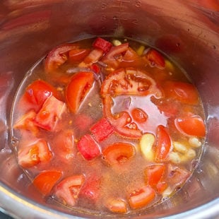 chopped tomatoes with cashews in a pot full of water