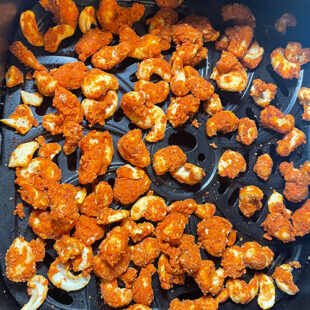 spicy coated cashews placed on air fryer