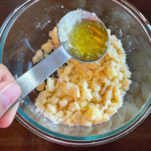 ghee being added to a bowl of khoya