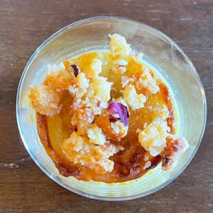 small dessert jar topped with crumble and dried rose petals