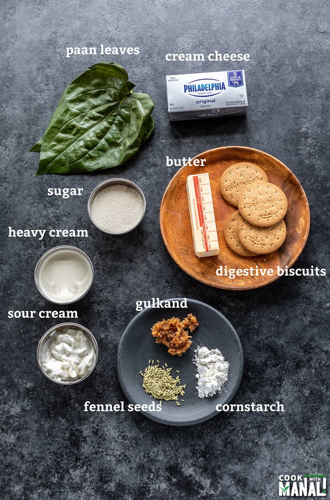 bowl of sugar, cream, sour cream, some paan leaves, biscuits all arranged on a board