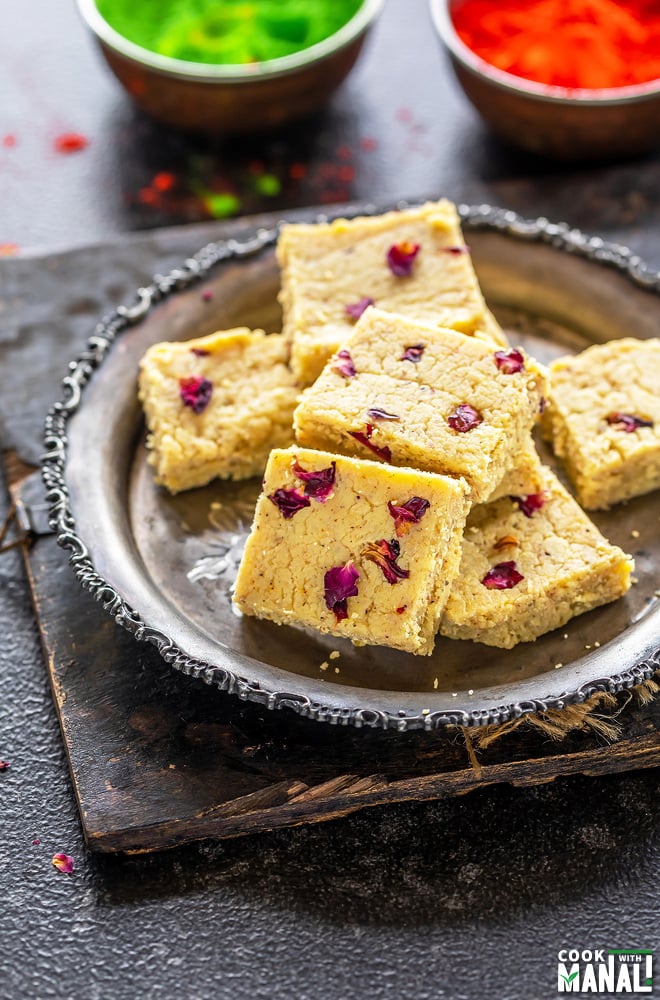 plate of thandai burfi with holi colors in the background