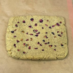 rolled dough for burfi placed on parchment paper