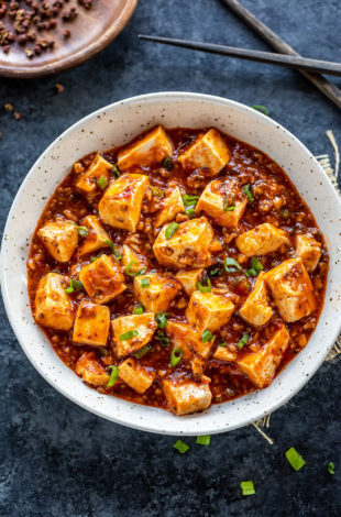 mapo tofu served in a white bowl and garnished with green onions