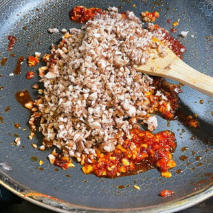 micned mushroom being added to a pan