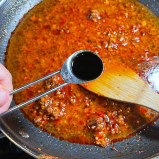 soy sauce being added to a pan