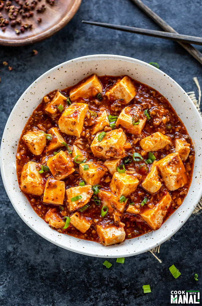 mapo tofu served in a white bowl and garnished with green onions