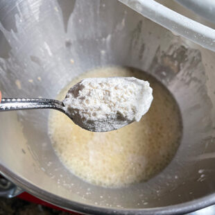 flour being added to wet ingredients in a bowl