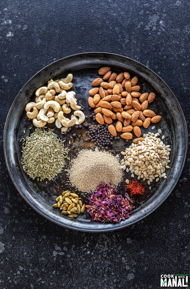 cashews, almonds, rose petals, fennel, cardamom and more spices placed on a plate