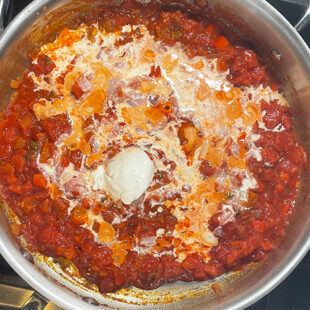 cream and sour cream being added to a pan with diced tomatoes
