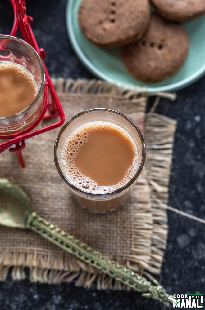 glass of chai with cookies placed on the side